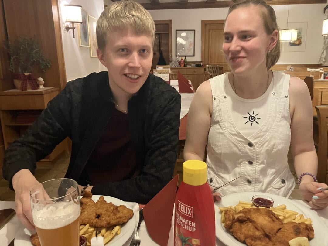 Bilder von unseren Mitgliedern Gemütliches Restaurant, zwei Personen, Schnitzel, Pommes, Bier, unterhalten sich, warme Atmosphäre, Felix Ketchup.