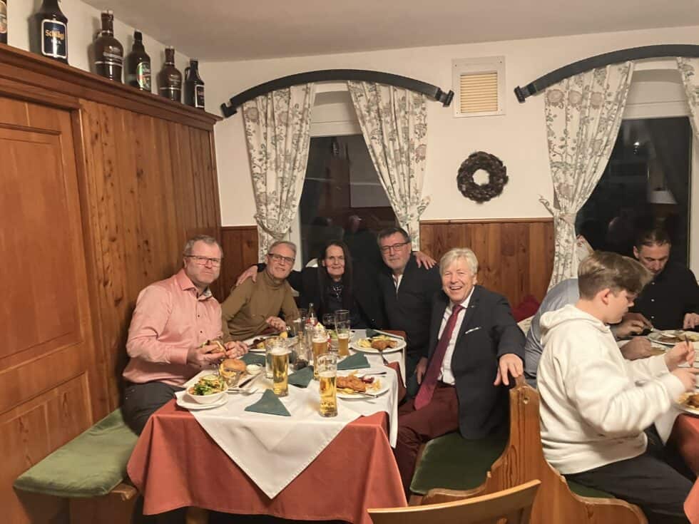 Gemütliches Familienessen in rustikalem Restaurant mit Schnitzel, Bier und herzlicher Atmosphäre.