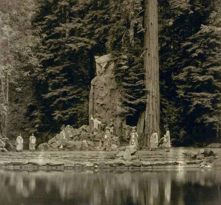 Bohemian Grove: Ein umfassender Bericht über den geheimnisvollen Herrenclub Mystisches Ritual im Redwood-Wald mit roben Gestalten, Steinstruktur und reflektierendem Wasser.