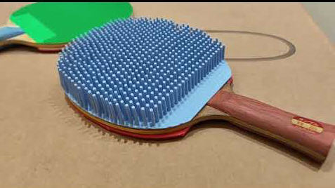 Einzigartige Tischtennisschläger mit außergewöhnlicher blauer und grüner Spieloberfläche.