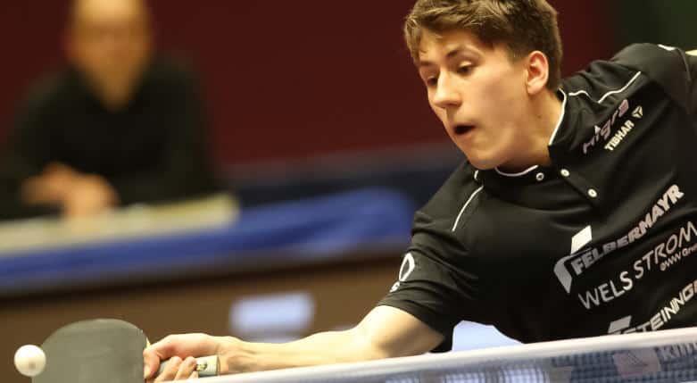 Junger Tischtennisspieler fokussiert, bereit zum Schlag im spannenden Match. Sportliche Konzentration pur.