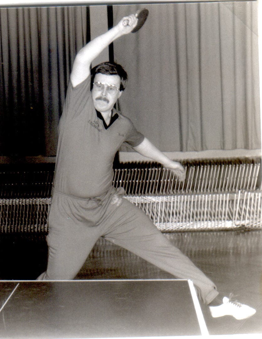 Tischtennis Leonding | Bilder „Tischtennis Leonding“ Mann beim Tischtennis-Spiel mit Schläger in dynamischer Pose, Schwarz-Weiß-Foto.