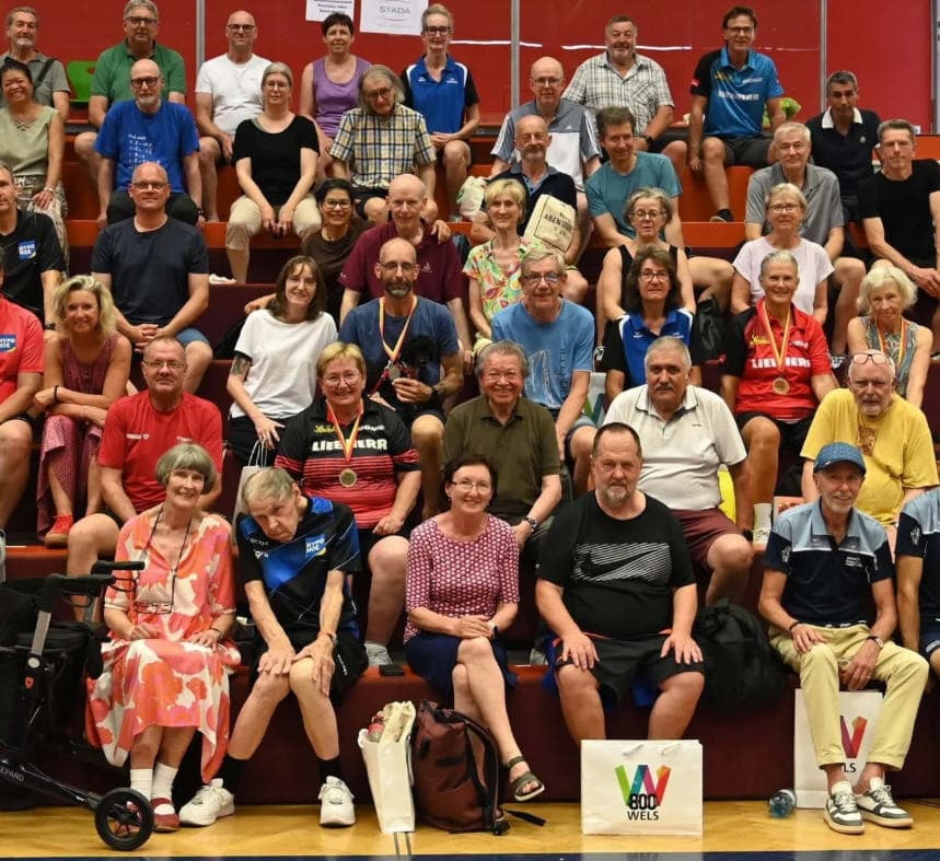 Senioren Tischtennis Turnier Wels – Gemeinschaft und Sportfreude Senioren Tischtennis Turnier Wels, Gruppenfoto Teilnehmer in Sportkleidung, Medaillen, Sporthalle.